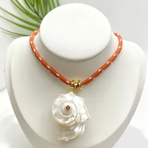 Dettaglio collana con pendente in conchiglia naturale, accessorio stile marino.