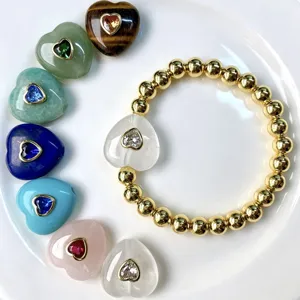 Detailaufnahme des Goldperlenarmbands mit Kristallherzanhänger und bunten Natursteinherzen.