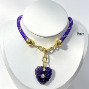 Purple braided cord necklace featuring gold-plated metal accents and carved crystal heart pendant.