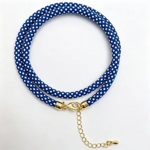 Blue and white braided rope necklace detail showcasing the gold clasp and extension chain.