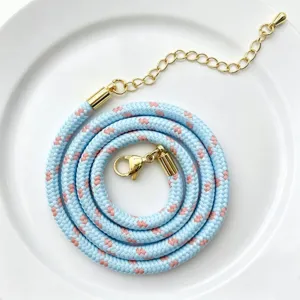 Nahaufnahme Detail von blau rosa geflochtenem Polyesterkernseil mit goldener Verschluss.