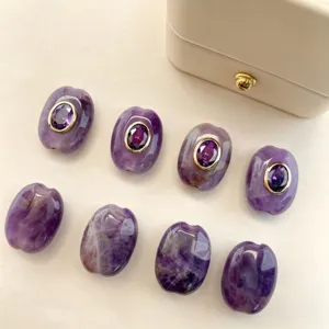 Natural stone spacer beads detail showing purple oval beads with gold-rimmed purple zircon.