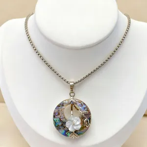 Close-up detail of the natural abalone shell and mother-of-pearl floral pendant necklace.