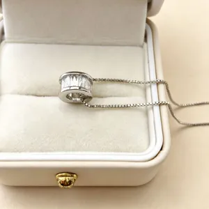 Detailopname van een 10 mm cilindrische zirkonia hangerkraal met fijne ketting in juwelendoosje.