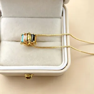Close-up detail shot of colorful zircon baguette wheel charm pendant in jewelry box.