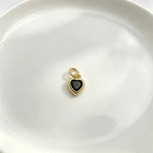 Detaillierte Nahaufnahme eines süßen herzförmigen Anhängers mit schwarzem Stein für Schmuck.