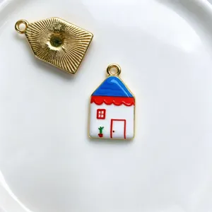 Close-up detail shot of cute enamel house pendant charm, copper plated DIY jewelry making.