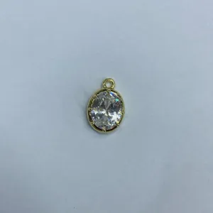 Dettaglio in primo piano del ciondolo ovale placcato oro con zircone brillante per gioielli fai da te.