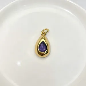 Exquisite gold teardrop pendant featuring a beautiful central purple crystal stone.