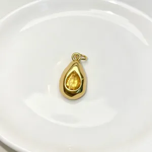 Exquisite drop-shaped gemstone pendant detail view, golden finish with a bright yellow crystal.