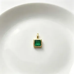 Nahaufnahme eines quadratischen grünen Zirkon-Anhängers aus vergoldetem Kupfer für DIY-Schmuck.