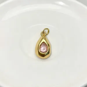 Exquisite teardrop gemstone pendant detail, featuring a glossy gold frame and pink stone.