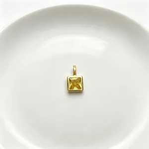 Nahaufnahme Detail eines quadratischen gelben Zirkon vergoldeten Anhängers für DIY Schmuck.