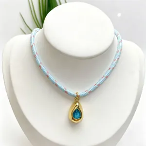 Exquisite braided rope necklace featuring a gold teardrop pendant with blue gemstone for women.