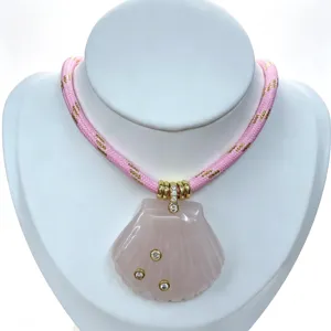 Nahaufnahme des eleganten geschnitzten rosa Kristallmuschel-Anhängers mit funkelnden Zirkonen.