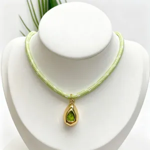 Chic light green braided rope necklace featuring a gold teardrop gemstone pendant