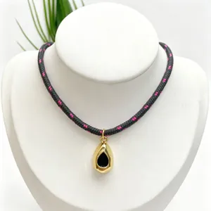 Detailed view of fashionable woven rope necklace featuring a gold teardrop pendant design.