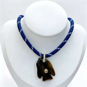 Detailed view of the natural stone fish pendant necklace with blue braided rope and gems.