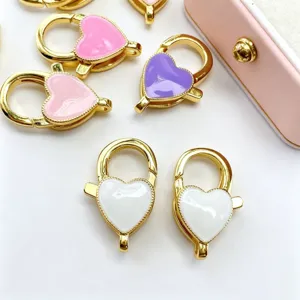 Détail de fermoir mousqueton en cœur, accessoire de bijoux à ressort coloré et émaillé.