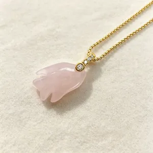 Close-up detail of a charming pink crystal fish pendant necklace with delicate gold chain.