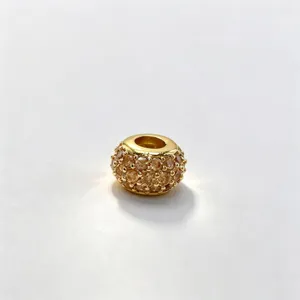 Close-up of gold micro-pave cubic zirconia large hole loose charm bead for DIY jewelry.