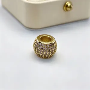Vista macro dettagliata di perla con foro grande in strass micro-incastonati dorati.