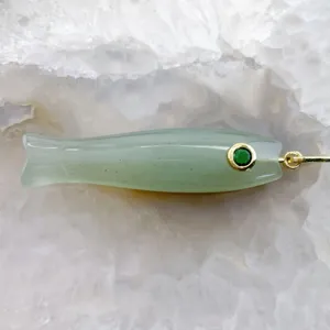 Dettaglio del ciondolo a forma di pesce in pietra naturale con occhio verde e anello dorato.