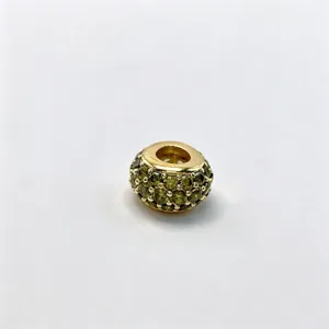 Detail shot of a gold-plated micro-set green crystal large hole DIY charm bead accessory