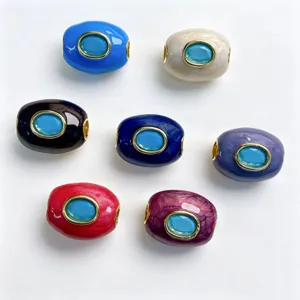 Gros plan de perles tonneau en émail coloré avec incrustation de pierre bleue pour bijoux.