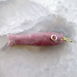 Ciondolo pesce in pietra rosa naturale con occhio in gemma rossa e anello dorato.