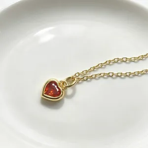 Vergoldete Halskette mit rotem Zirkon in Herzform, elegantes Detail fur Damenschmuck.