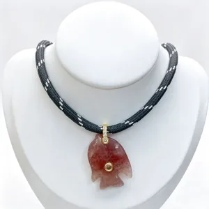 Natural stone carved fish pendant necklace with black rope chain and crystal detail.
