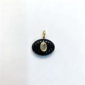 Ciondolo ovale in pietra nera intagliata con zircone centrale e dettagli dorati. Dettaglio.