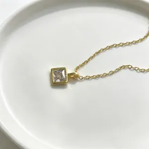 Zarte goldene quadratische Anhänger Halskette Detailaufnahme mit klarem Zirkonia Stein.