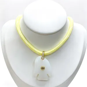 Exquisite white carved fish pendant necklace with yellow braided cord and sparkling crystal details.