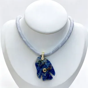 Natural stone tropical fish pendant necklace with gold accents on a thick woven cord display.