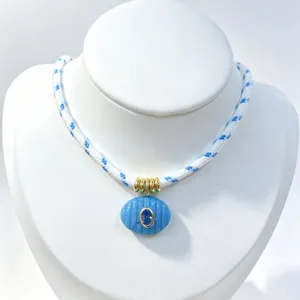 Vista dettagliata della bellissima collana in corda intrecciata blu con pietra e zircone.