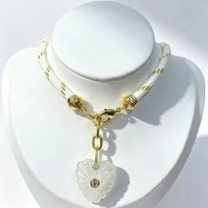 Exquisite white carved crystal heart pendant necklace with gold hardware and braided rope chain.