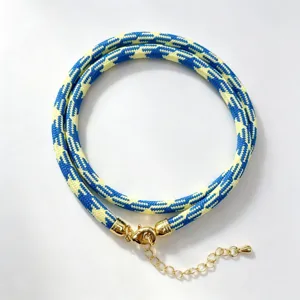 Blue and yellow woven rope necklace detail showing the intricate mesh pattern and golden clasp.