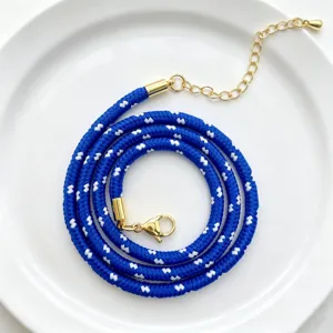 Detailaufnahme einer 3mm blauen geflochtenen Polyester Kette mit goldenen Beschlägen.