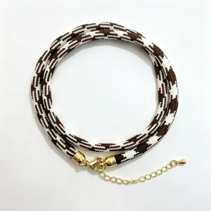 Brown and white woven cord necklace with gold lobster clasp and extension chain jewelry accessory.