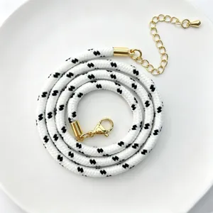 Detailaufnahme einer 3mm schwarz-weißen Polyester Rundschnur Kette mit goldener Hardware.
