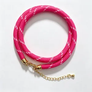 Pink braided rope necklace with gold hardware, elegant handmade cord accessory detail view.