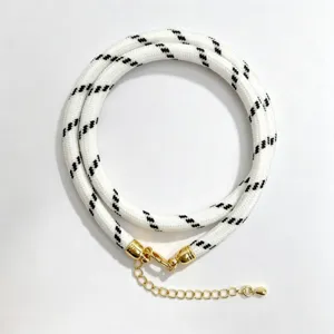 Black and white woven rope necklace with gold hardware detailed shot displaying texture.