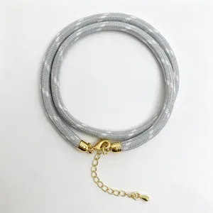 Grey braided rope cord necklace detail with golden metal clasp and adjustable extension chain