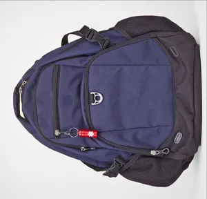 Detailed view of dark blue backpack with durable straps and attached red aluminum pill holder fob.