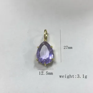 Ciondolo in zirconia cubica viola a pera con montatura dorata, dettaglio di gioiello squisito.