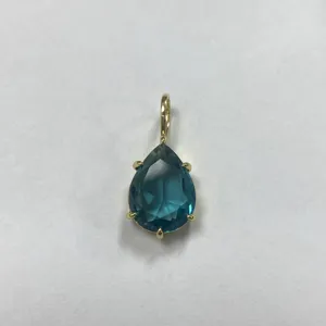 Primo piano dettagliato di un elegante ciondolo in zircone cubico a goccia color oro.