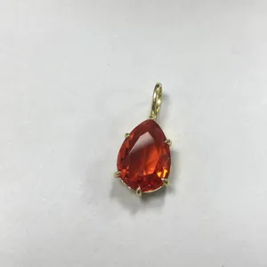 Primo piano del ciondolo in zircone arancione a pera con montatura dorata, dettaglio elegante.