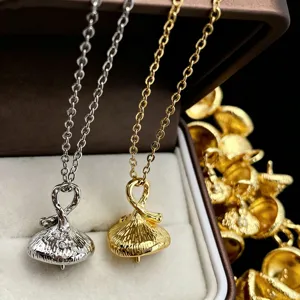 Gros plan détaillé du collier pendentif cloche en cuivre plaqué avec zircone étincelante.